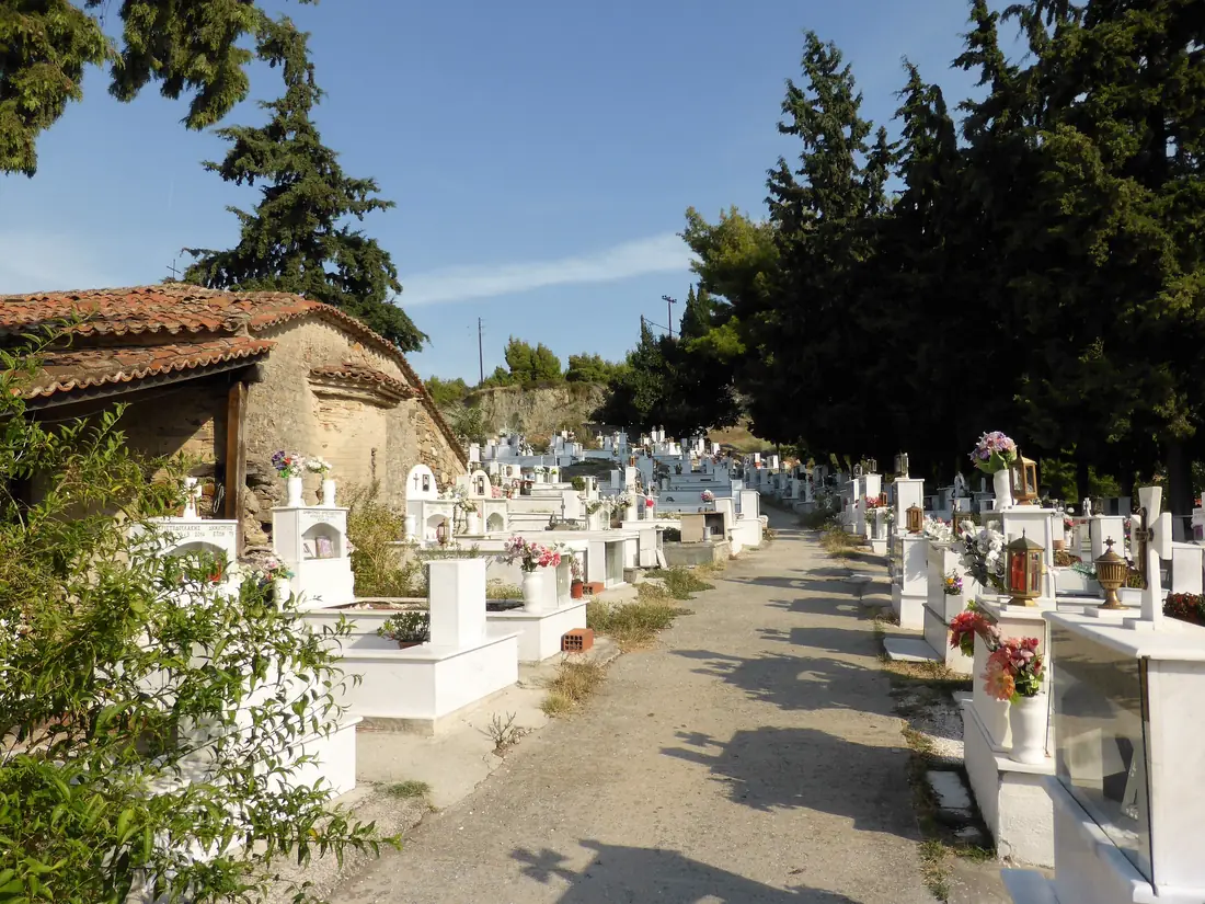 Nikiti's old cemetery chapel among white graves and cypresses