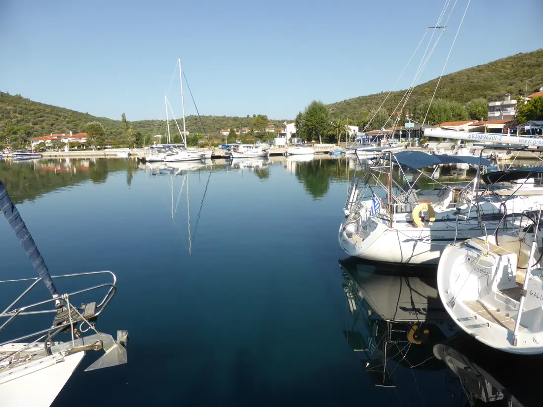 Sailing boats and fishing boats in the sheltered natural harbour of Porto Koufo