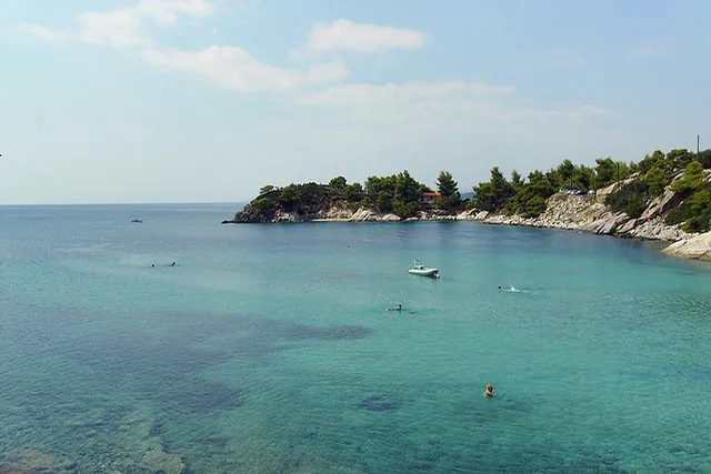 The bay at Spathies near Nikiti with turquoise water and a wooded headland